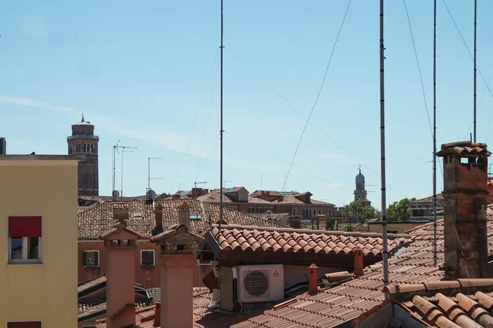 Toits de tuiles rondes hérissés de conduits de cheminée et d'antennes